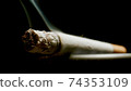 MACRO: Cigarette smoking on black background. 74353109