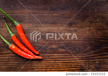 Chili Peppers on wood background 74353133