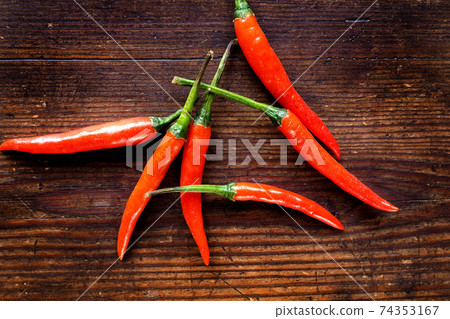 Group of chilli peppers on wood background Group of chilli peppers on wood background 74353167