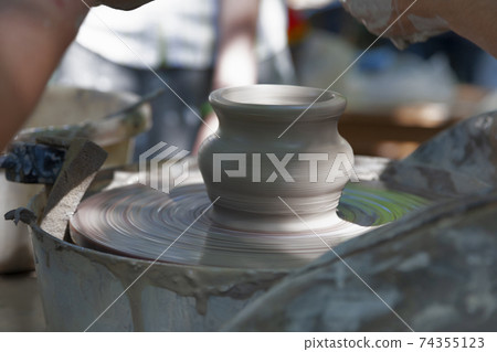Potter shaping a ceramic pot 74355123