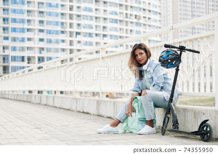 Young woman resting on curb Young woman resting on curb 74355950
