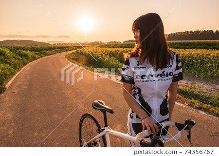 Female road racer looking back Female road racer looking back 74356767