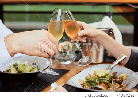 couple having amazing lunch and drink champagne at outdoor restaurant couple having amazing lunch and drink champagne at outdoor restaurant 74357282