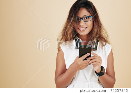 Woman choosing music on smartphone 74357845