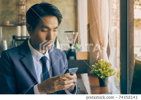 Zoom View Front Right Asian Businessman Chat Online by Smartphone in Vintage Tone Zoom View Front Right Asian Businessman Chat Online by Smartphone in Vintage Tone 74358141