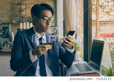 Front Right Asian Businessman Wear Glasses Using Smartphone for Online Payment in Vintage Tone Front Right Asian Businessman Wear Glasses Using Smartphone for Online Payment in Vintage Tone 74358170