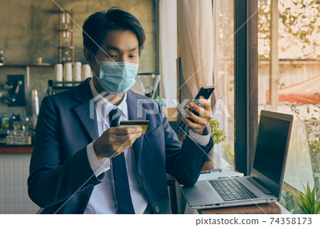 Front Right Asian Businessman Wear Face Mask Using Smartphone for Online Shopping in Vintage Tone Front Right Asian Businessman Wear Face Mask Using Smartphone for Online Shopping in Vintage Tone 74358173