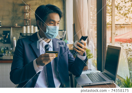 Front Right Asian Businessman Wear Face Mask Using Smartphone for Online Payment in Vintage Tone Front Right Asian Businessman Wear Face Mask Using Smartphone for Online Payment in Vintage Tone 74358175