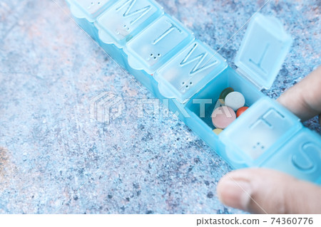 close up of pills and capsule in a pill box  74360776