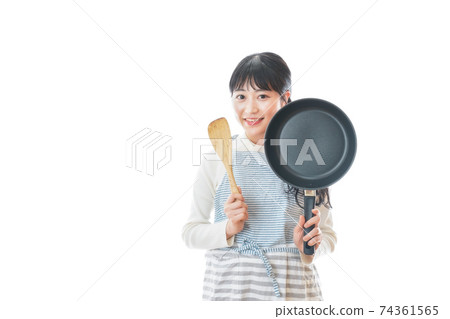 Newlywed woman cooking at home 74361565
