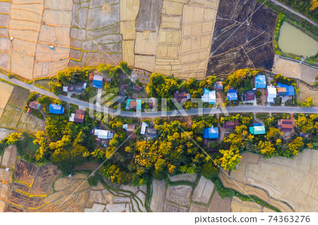 Top view of rural village surrounded by rice field in Nan province, Thailand Top view of rural village surrounded by rice field in Nan province, Thailand 74363276