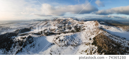 Aerial panoramic view of snow covered high mountains. Aerial panoramic view of snow covered high mountains. 74365280