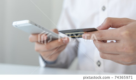 Businessman use mobile phones to register for security Online with a credit card to buy products online through application, Online shopping or Internet technology concept. Businessman use mobile phones to register for security Online with a credit card to buy products online through application, Online shopping or Internet technology concept. 74365971