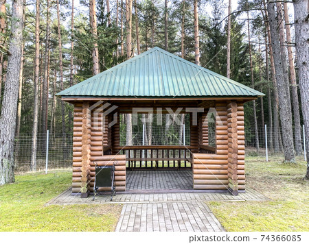 Large wooden gazebo on background of forest Large wooden gazebo on background of forest 74366085