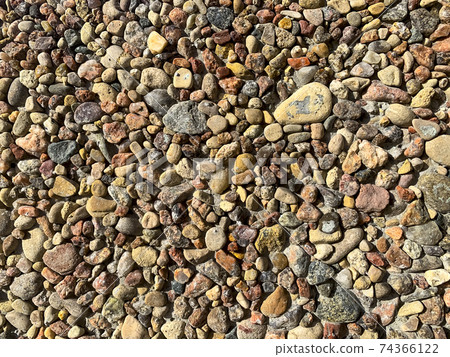 Decorative wall of small multi-colored pebbles. Photo 74366122