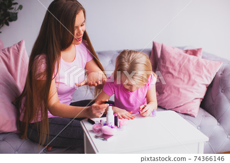 the young mother and daughter are doing manicure the young mother and daughter are doing manicure 74366146