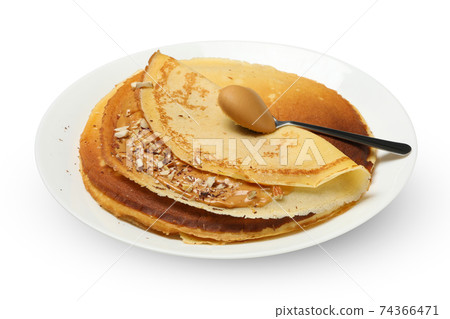 Plate of crepes with peanut butter and nuts isolated on white background Plate of crepes with peanut butter and nuts isolated on white background 74366471