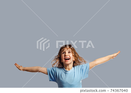 little girl jumps on a gray background little girl jumps on a gray background 74367040
