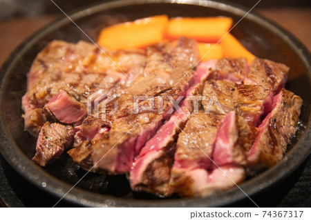 Beef steak baked on an iron plate 74367317