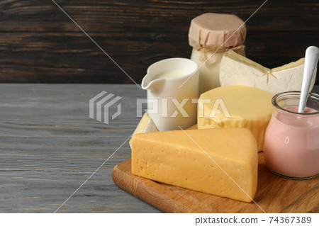 Different fresh dairy products on gray wooden background 74367389