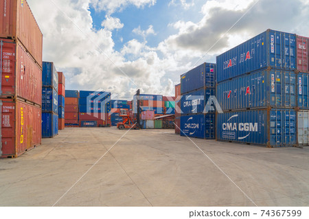 Shipping container site loading by crane in logistic port warehouse storage factory manufacturing business transportation import and export goods of freight business carrier. Shipping container site loading by crane in logistic port warehouse storage factory manufacturing business transportation import and export goods of freight business carrier. 74367599