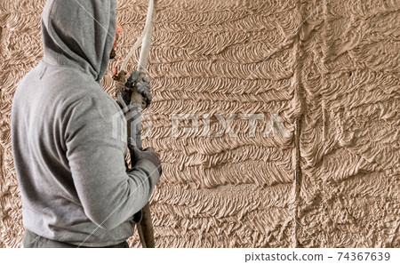 Man with plastering pump. Walls with gypsum plaster or cement plaster. Plasterer operating sprayer equipment machine for spraying layer putty plaster finishing on brick wall. Man with plastering pump. Walls with gypsum plaster or cement plaster. Plasterer operating sprayer equipment machine for spraying layer putty plaster finishing on brick wall. 74367639