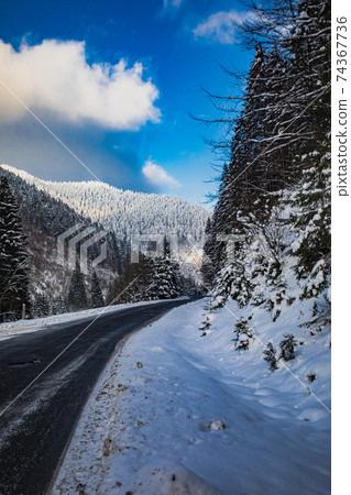 Mountain road while snow blizzard is dangerous 74367736