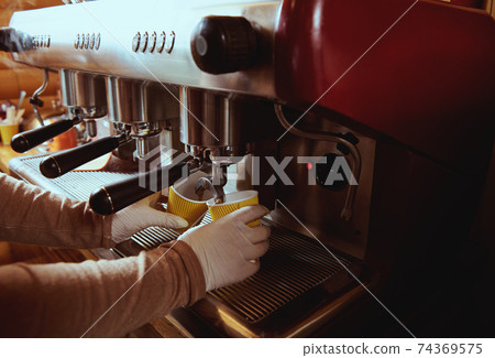 Close-up of espresso pouring from coffee machine. Professional coffee brewing Close-up of espresso pouring from coffee machine. Professional coffee brewing 74369575