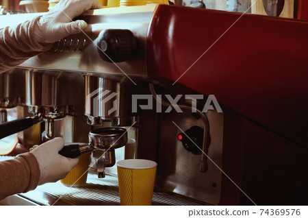 Female barista hand holding ground coffee for preparing espresso. Closeup. Female barista hand holding ground coffee for preparing espresso. Closeup. 74369576