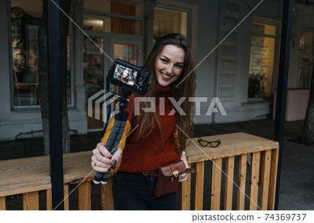 Content creator, blogger, vlogger young woman taking selfies, filming herself and having fun on city street. Content creator, blogger, vlogger young woman taking selfies, filming herself and having fun on city street. 74369737