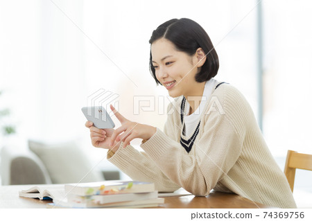 High school students studying while looking at their smartphones 74369756