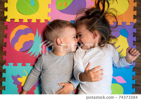 childhood, family friendship, games - close up portrait Two funny joy happy smiling little toddler peschool kids siblings twins brother with sister have fun lie playing on puzzles mat at home indoors childhood, family friendship, games - close up portrait Two funny joy happy smiling little toddler peschool kids siblings twins brother with sister have fun lie playing on puzzles mat at home indoors 74371084