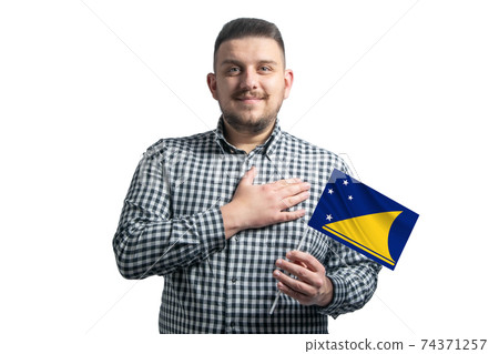 White guy holding a flag of Tokelau and holds his hand on his heart isolated on a white background With love to Tokelau 74371257