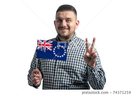 White guy holding a flag of Cook Islands and shows two fingers isolated on a white background White guy holding a flag of Cook Islands and shows two fingers isolated on a white background 74371259