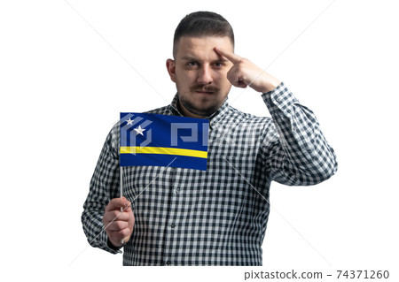 White guy holding a flag of Curacao and a finger touches the temple on the head isolated on a white background White guy holding a flag of Curacao and a finger touches the temple on the head isolated on a white background 74371260
