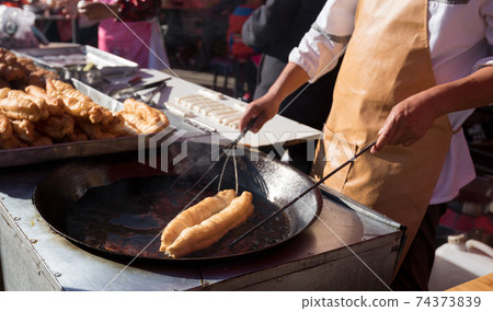 Chinese traditional street breakfast food,Youtiao (deep-fried breadstick) under cooking Chinese traditional street breakfast food,Youtiao (deep-fried breadstick) under cooking 74373839
