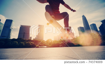 Asian woman skateboarder skateboarding in modern city 74374009