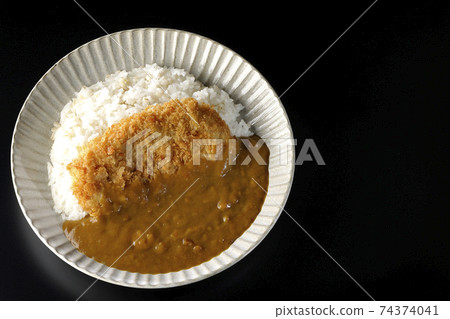 A black background shot of a cutlet curry with a large pork cutlet in the middle (overhead view) 74374041