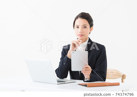 A woman in a suit doing desk work A woman in a suit doing desk work 74374796