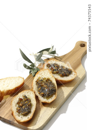 在果仁法式麵包上塗上堅果油，然後食用（白色背景） 74375543