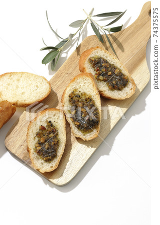 Apply olive oil with nuts on the carved French bread and eat (white background) Apply olive oil with nuts on the carved French bread and eat (white background) 74375575