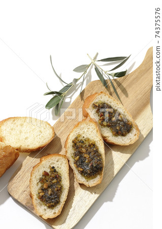 在果仁法式麵包上塗上堅果油,然後食用(白色背景) 在果仁法式麵包上塗上堅果油,然後食用(白色背景) 74375576