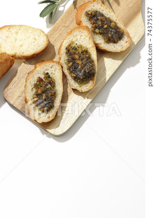 在果仁法式麵包上塗上堅果油，然後食用（白色背景） 74375577