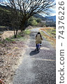 Back view of a girl riding a bicycle in nature 1 74376226