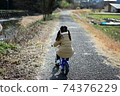 Back view of a girl riding a bicycle in nature 2 74376229