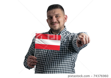 White guy holding a flag of Austria and points forward in front of him isolated on a white background White guy holding a flag of Austria and points forward in front of him isolated on a white background 74376960