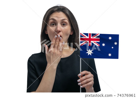 Happy young white woman holding flag of Australia and covers her mouth with her hand isolated on a white background Happy young white woman holding flag of Australia and covers her mouth with her hand isolated on a white background 74376961
