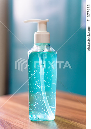 Blue alcohol hand sanitizer on wooden In the room at home background,Concept of Prevention of the spread of COVID-19 virus infection Blue alcohol hand sanitizer on wooden In the room at home background,Concept of Prevention of the spread of COVID-19 virus infection 74377483