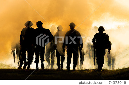Silhouettes of army soldiers in the fog against a sunset, marines team in action, surrounded fire and smoke, shooting with assault rifle and machine gun, attacking enemy Silhouettes of army soldiers in the fog against a sunset, marines team in action, surrounded fire and smoke, shooting with assault rifle and machine gun, attacking enemy 74378046