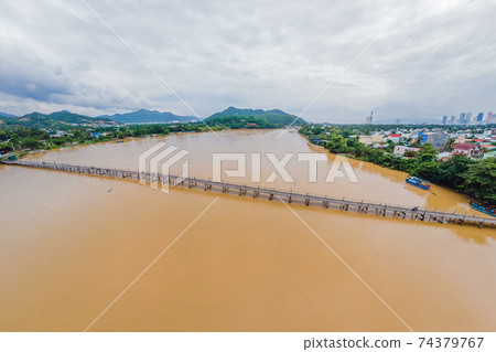 Aerial view of old wooden bridge over the river. Drone 74379767